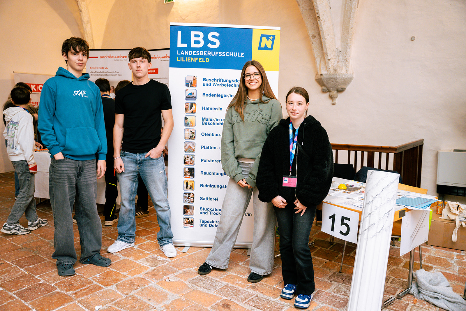 LBS Lilienfeld: vier Jugendliche vor einem Info-Stand mit Berufsbezeichnungen
